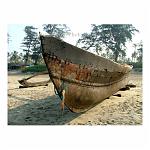A wooden boat waits patiently on the beach. Goa, India.